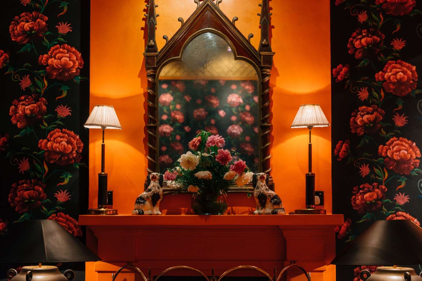 The Peony Room: a Gothic mirror over a saffron mantel with peony wallpaper on either side.