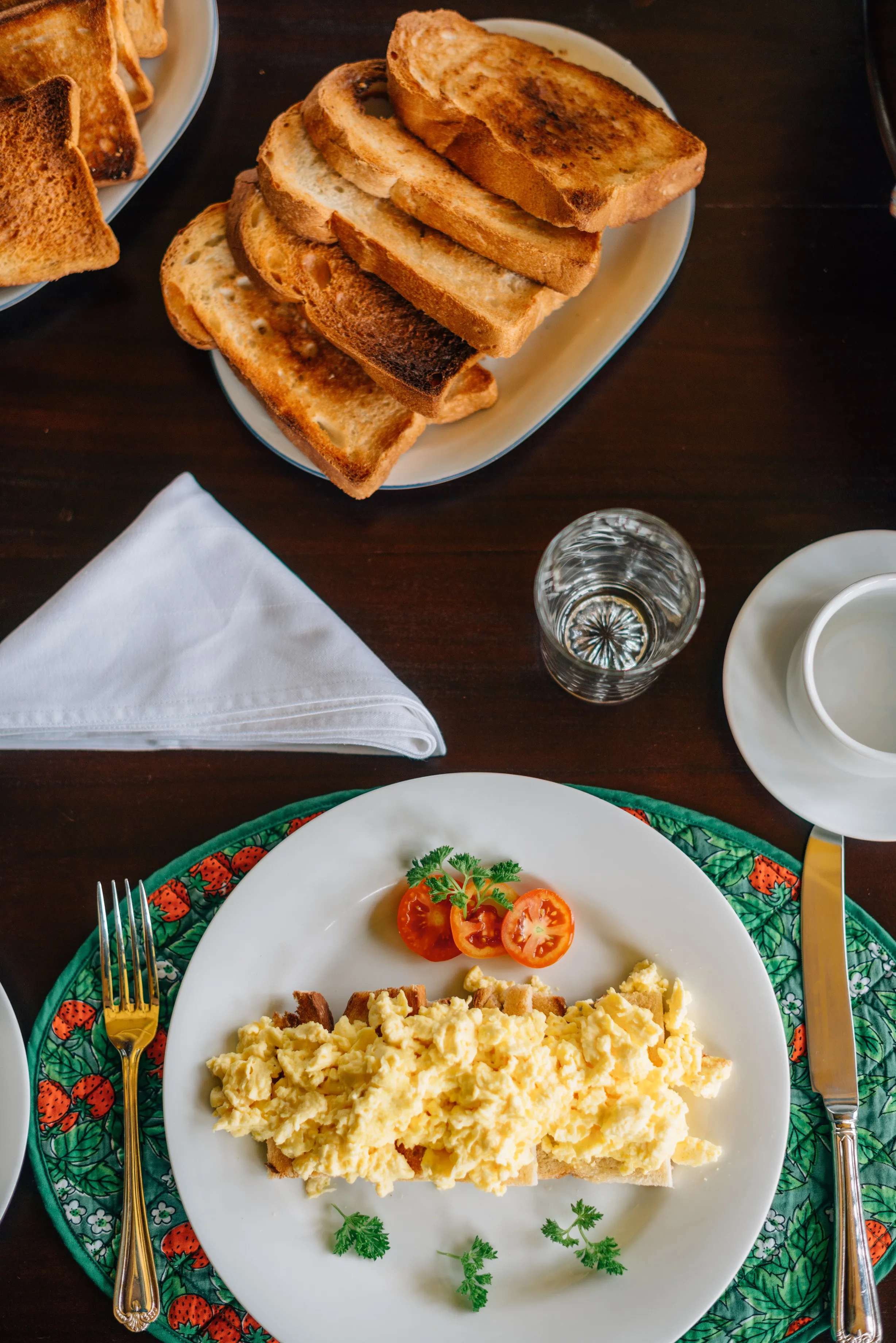Scrambled eggs on toast with tomato and parsley.