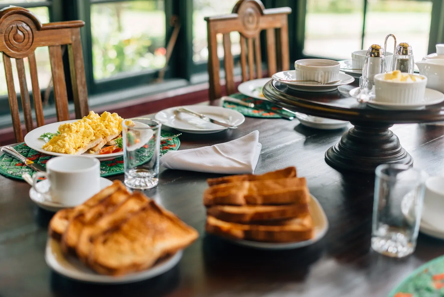 Breakfast laid by green-framed windows.